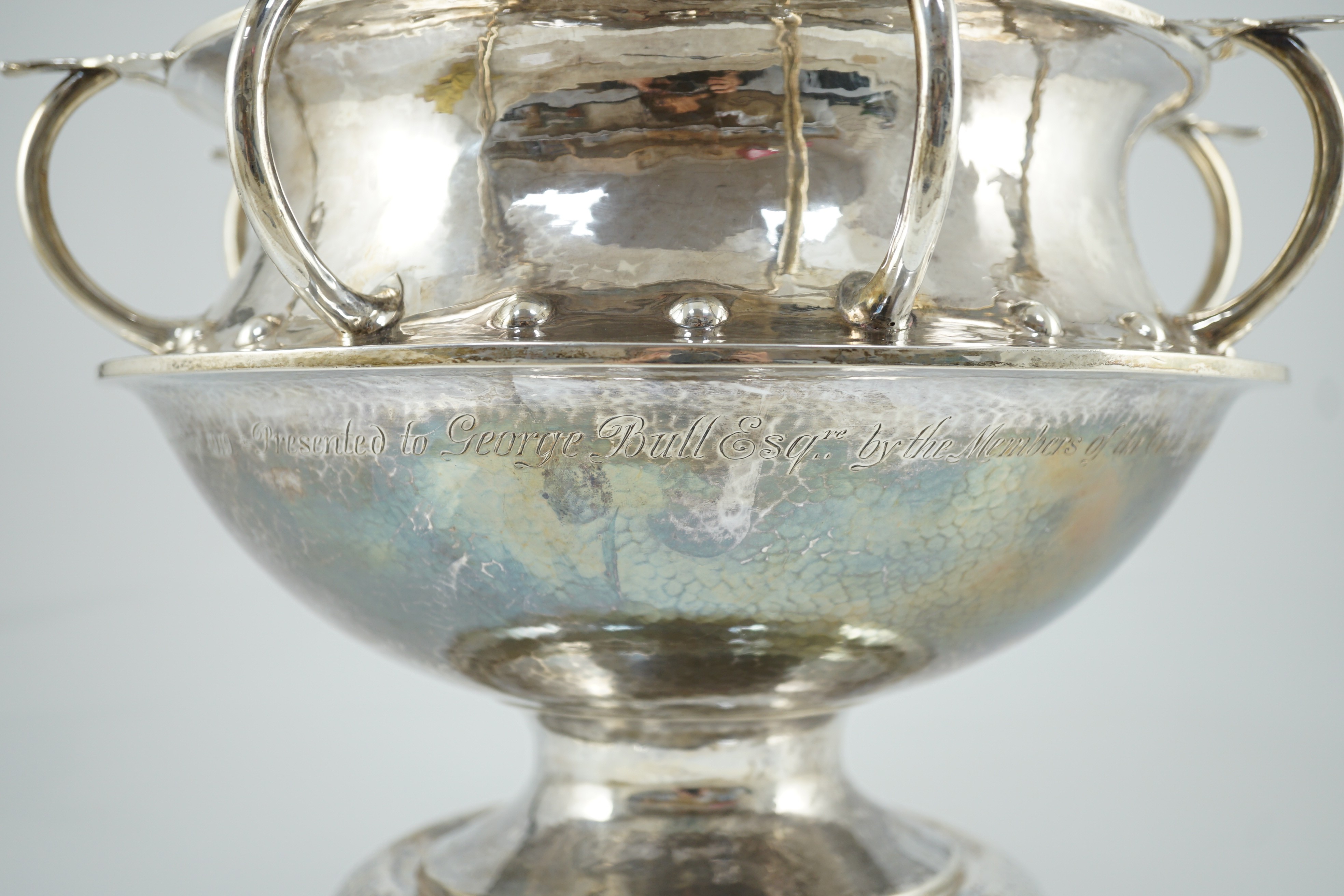 A George V Arts & Crafts planished silver octuple handled pedestal punch bowl, by Albert Edward Jones